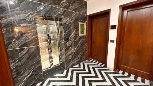 a hallway with a black and white tile floor at Hotel Haven Lahore in Lahore