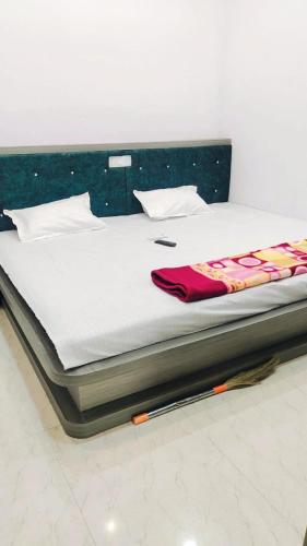 a bed with white sheets and a red blanket on it at Hotel sawariya in Godarpura