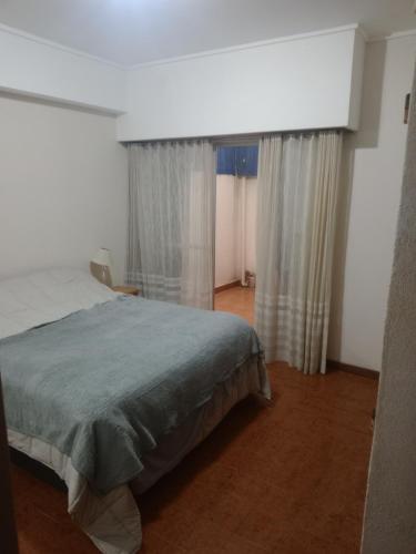 a bedroom with a bed and two windows with curtains at Arco Iris in Miramar