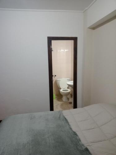 a bedroom with a bed and a bathroom with a toilet at Arco Iris in Miramar