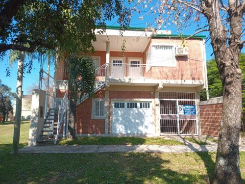 a red brick house with a white garage at Coastal Apartment in Monte Caseros