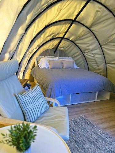 a bedroom with a bed in a tent at Fenlea Resort Glamping Cocoon in Hampton