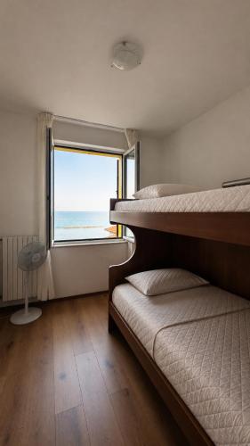 a bedroom with two bunk beds and a large window at Villa sul mare di Cupra in Cupra Marittima