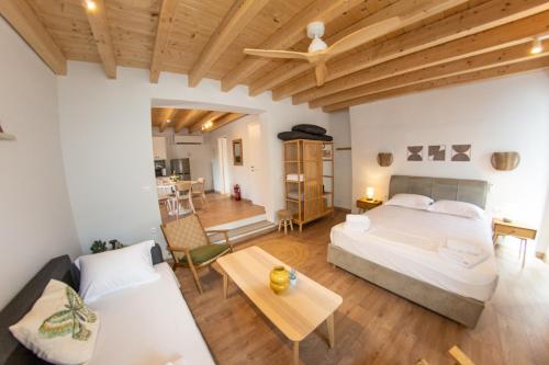 a bedroom with a bed and a couch and a table at Kantouni Corfu in Potamós