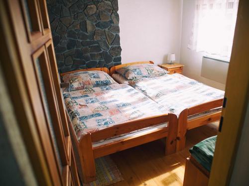 a bedroom with a wooden bed in a room at Zelená chalúpka in Spišská Nová Ves