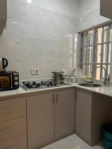 a white kitchen with a stove and a sink at Hayorttas Apartment in Cardoso