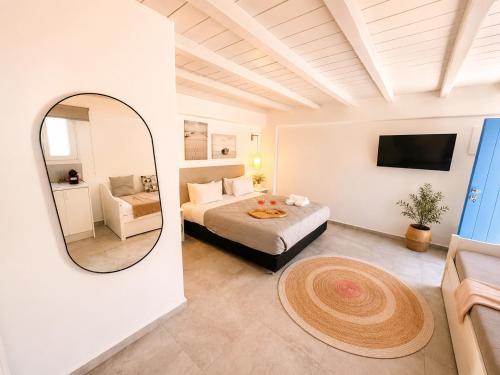 a hotel room with a bed and a mirror at ELEVEN KEYS APARTMENTS in Vrisi/ Mykonos