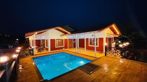 a house with a swimming pool at night at Snehdeep Villa, Konkan Trail in Dapoli