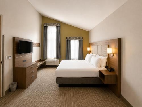 a hotel room with a bed and a flat screen tv at Holiday Inn Express Durham-UNH by IHG in Durham