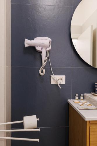 a white hairdryer on a wall in a bathroom at Corte EDN7 in Sannicandro di Bari