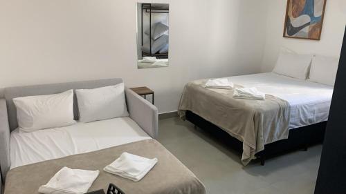 a room with a bed and a couch and a mirror at Chacara Stay in São Paulo