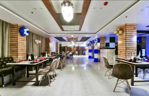 una sala da pranzo con tavoli e sedie in un ristorante di Palash hotel a Dānāpur