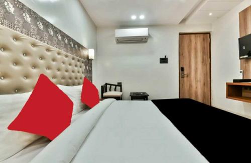 una camera da letto con un grande letto bianco con cuscini rossi di Palash hotel a Dānāpur