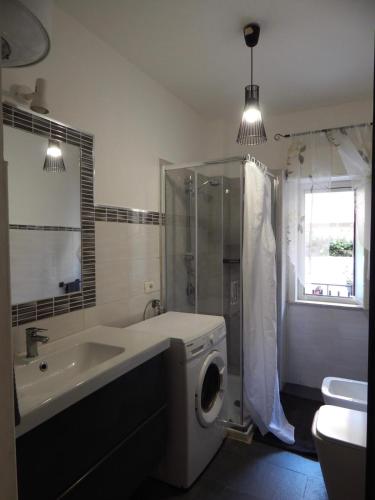 a bathroom with a sink and a washing machine at Suli e Sali Apartment in Calatabiano