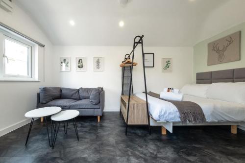 a bedroom with a bed and a couch at The Snug - Cosy Annexe Hideaway in Portishead