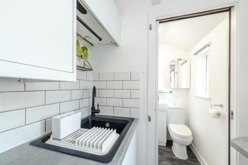 a white bathroom with a sink and a toilet at The Snug - Cosy Annexe Hideaway in Portishead