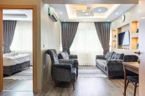 a living room with a couch and chairs and a bed at Saltanat Apartment in Istanbul