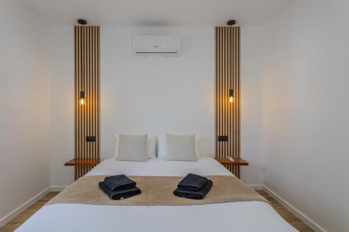 a bedroom with a bed with two towels on it at The Frenchie's House in Rabo de Peixe