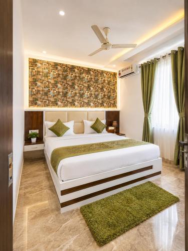 a bedroom with a large white bed with green rugs at Hotel Boston Rooms by SOT - Affordable Stay near Taj #Parking #Ac #2 min drive to Taj in Agra
