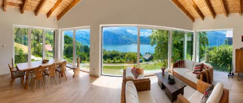 a living room with a view of a lake and mountains at Das Mondsee-Retreat in Innerschwand