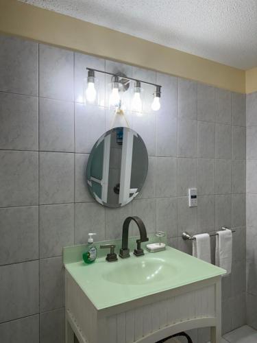 a bathroom with a sink and a mirror at NMG Comforts in Roseau