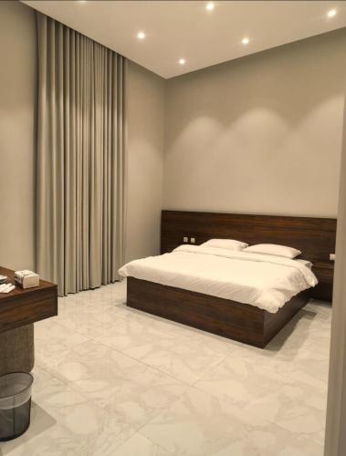 a bedroom with a large bed and a desk at دره العروس الشاطي in Jeddah