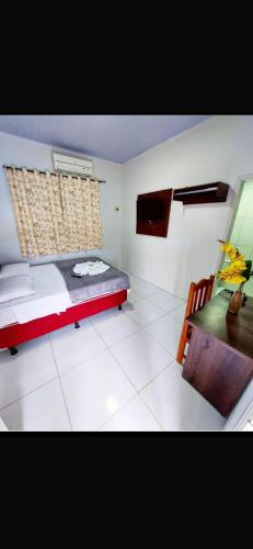 a bedroom with a bed and a table and a desk at Hotel Mirage in Alta Floresta