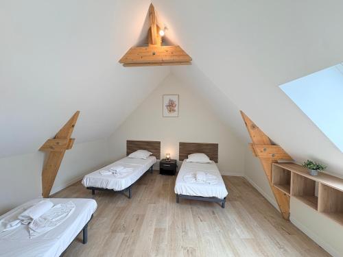 a attic room with two beds and a staircase at Le Cerf in Montmacq