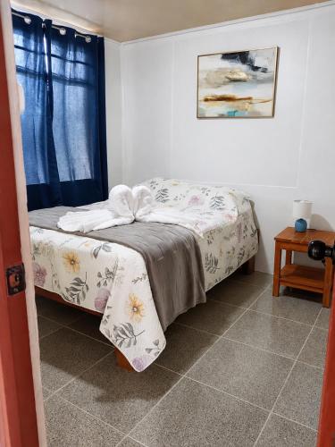 a small bedroom with a bed and a window at Arenal Rental CASA PALMERA UNO in Arenal