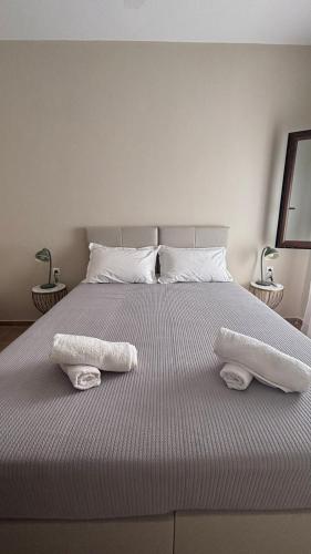 a bedroom with a bed with two towels on it at aganta apartments in Olympiada