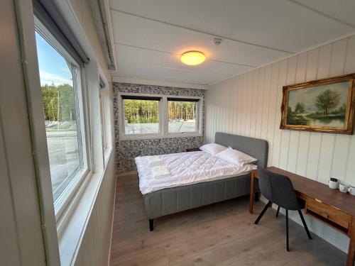 a bedroom with a bed and a desk and a window at Halden Motell in Halden