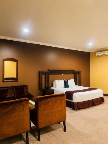 a hotel room with a bed and a chair at The Country Inn Hotel in Kigali