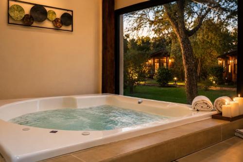 a jacuzzi tub in a room with a window at Cabañas Boutique Pipi Cucu in Colón