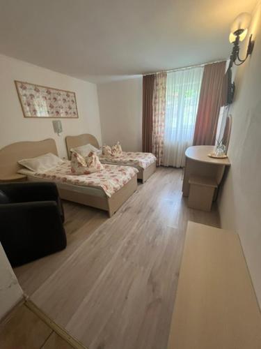 a small room with two beds and a table at Tranzit in Mihai Viteazu