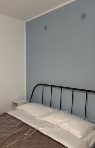a bed in a white room with a metal frame at Casa Nica in Naro