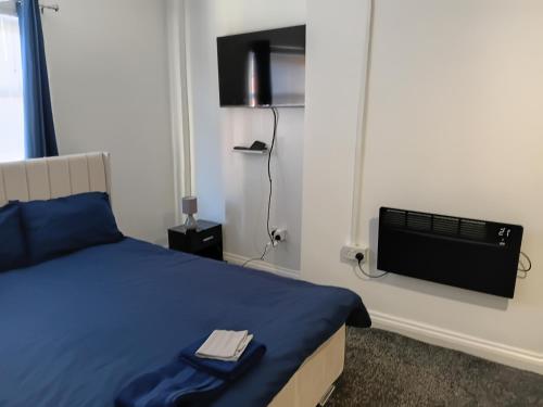 a bedroom with a bed and a tv on the wall at Studio Sleeps 2 with Parking in Oldbury