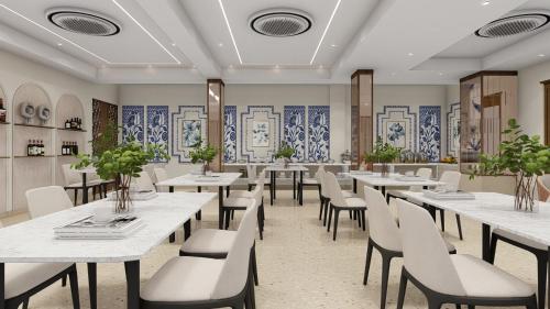 a restaurant with white tables and chairs and blue tiles at Hotel Vaarya Inn in Lucknow