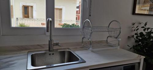 a kitchen sink with a dish drying rack next to a window at Espectaculares Aptos Castillo de Bellver in Camas