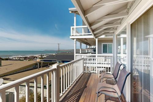 a balcony with two chairs and a view of the ocean at Blue Door Retreat in Cayucos