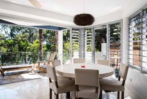 uma sala de jantar com uma mesa branca e cadeiras em Park Cove Apartment 1, Little Cove em Noosa Heads