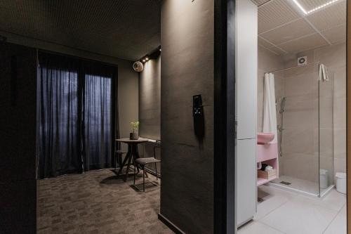 a bathroom with a shower and a table in a room at Hedonist SPA in Jagodina