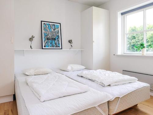 a white bedroom with a bed in a room at Hals Apartment 100m from Beach in Hals