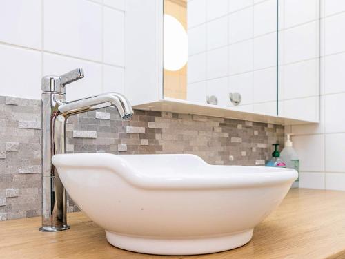 a white sink in a bathroom with a mirror at Hals Apartment 100m from Beach in Hals