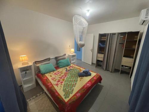 a bedroom with a large bed with green pillows at colibris Location SAINTE-ANNE in Sainte-Anne