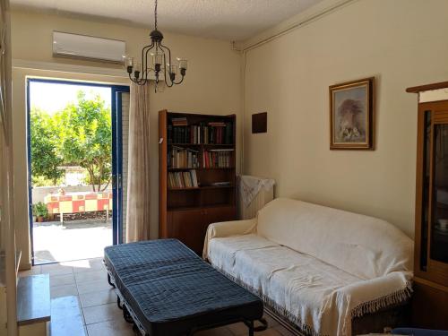 a living room with a couch and a book shelf at Dora's Sweet Home in Mytikas