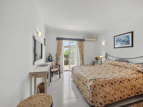 a hotel room with a bed and a desk and a window at Casa Trajlon in Praia do Carvoeiro