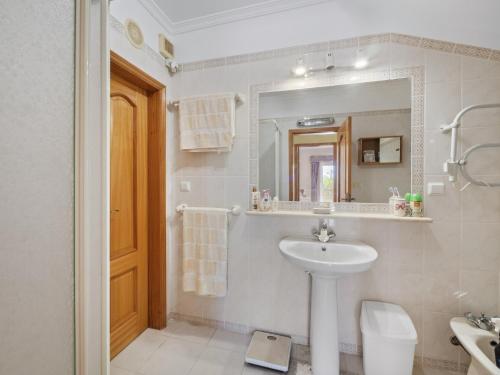 a bathroom with a sink and a mirror and a toilet at Casa Trajlon in Praia do Carvoeiro