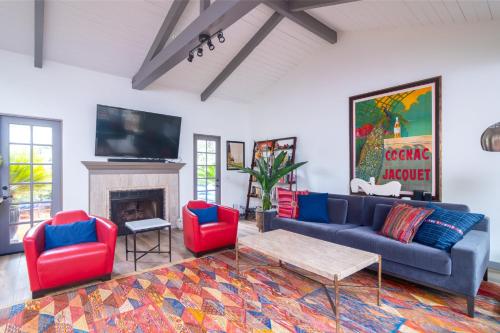 a living room with a blue couch and red chairs at Casa Alegria in Santa Barbara