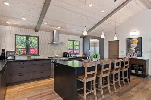a kitchen with a large island with bar stools at Casa Alegria in Santa Barbara