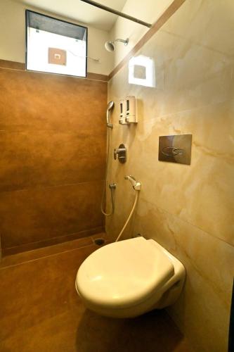 a bathroom with a toilet and a window at Luxury Hotel Aura Residency in Rāiwāla